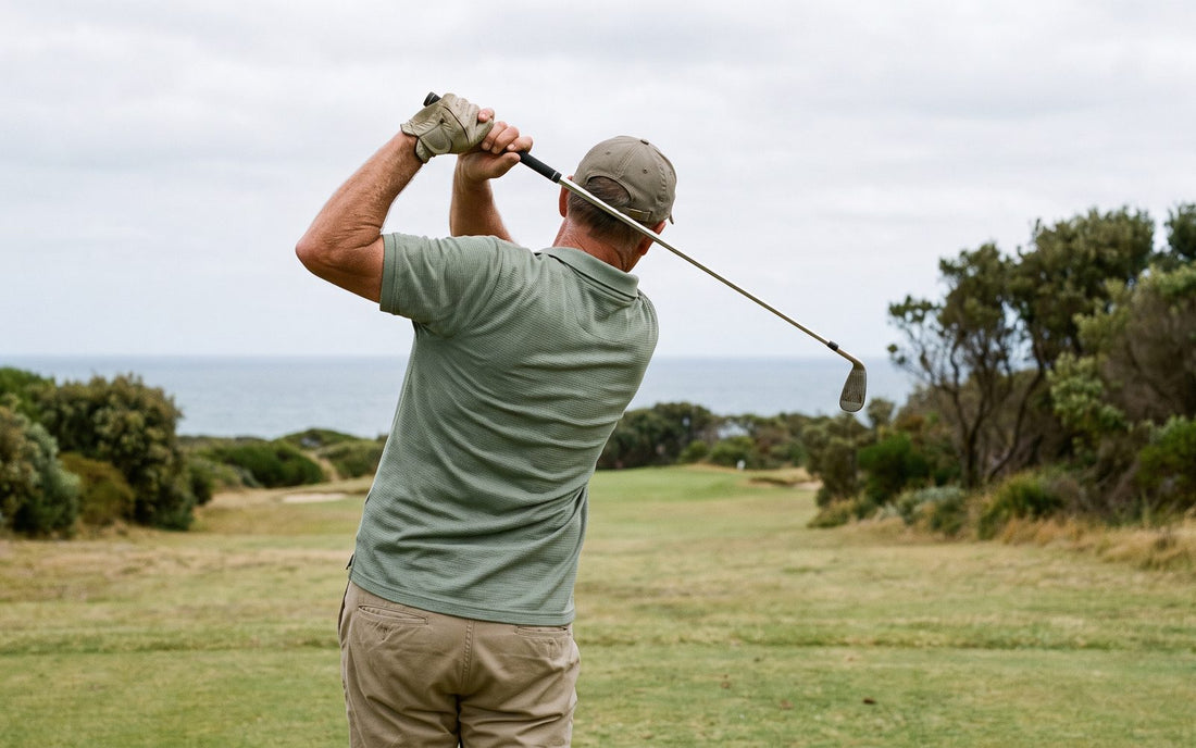 Golfer in his fifties at the top of his backswing on an Australian coastal course